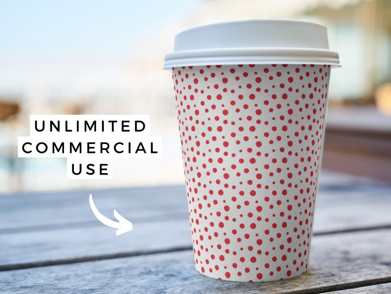 May include: A white to-go coffee cup with a red polka dot pattern. The cup is sitting on a wooden table.