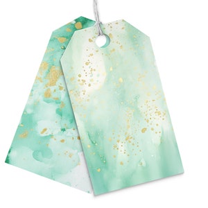 K&ouml;nnte beinhalten: Zwei gr&uuml;ne und goldene Geschenkanh&auml;nger mit Aquarelldesign. Die Anh&auml;nger haben oben ein Loch f&uuml;r eine Schnur oder ein Band.