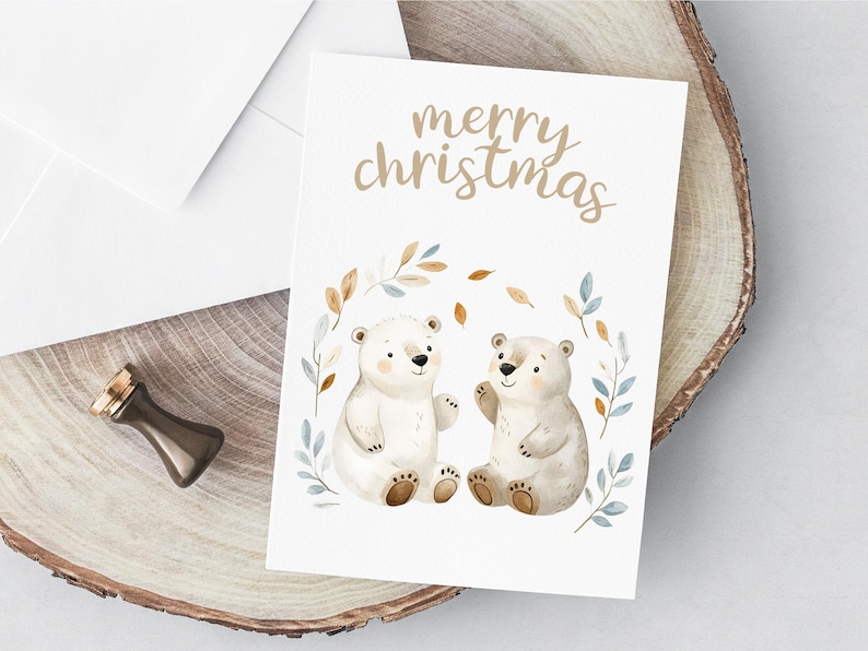 以下が含まれることがあります： 白いカードに、茶色の文字で「merry christmas」と書かれています。茶色の鼻をした白いホッキョクグマが2匹、茶色と青の葉の輪の中に並んで座っています。