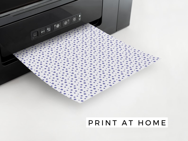 May include: A sheet of paper with a purple polka dot pattern is being printed from a black printer. The text "PRINT AT HOME" is visible below the paper.