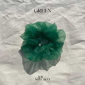 May include: Green, fluffy,  mesh hair scrunchie.  The scrunchie is made of a soft, sheer fabric and is perfect for adding a touch of color to any hairstyle.