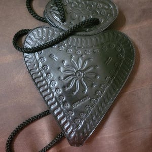 Cartera de piel negra con grabado de palas de Argentina