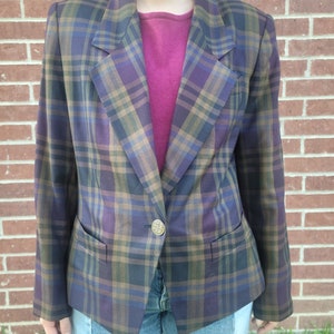 May include: A plaid blazer with a single button closure. The blazer is brown, purple, green, and blue.