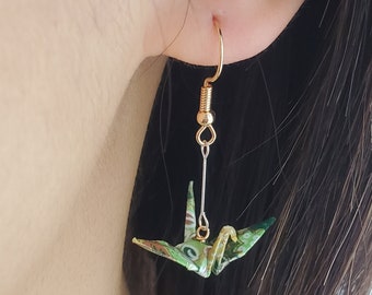 May include: Green and gold origami crane dangle earrings with a gold hook and a silver chain.