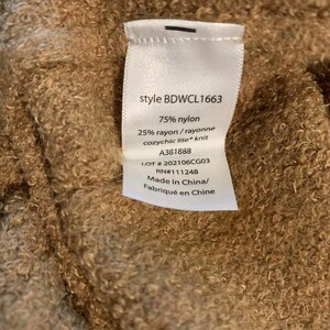 May include: A close-up of a label with the text "style BDWCL1663", "75% nylon", and "25% rayon/rayonne cozychic lite knit". The label also includes the numbers "A381888", "LOT #202106CG03", and "RN#111248".