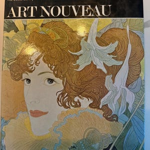 May include: A book titled Art Nouveau from The Colour Library of Art featuring 54 full colour illustrations. The cover displays a detailed portrait of a person with wavy auburn hair, adorned with white lily flowers, set against a yellow background.