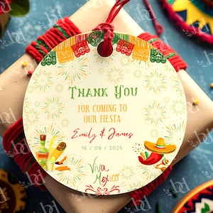 May include: A round gift tag with a festive Mexican fiesta theme. The tag features the text "Thank You" and "Viva Mexico" with illustrations of a sombrero, chili pepper, and tequila bottle. The tag is tied to a wrapped gift with red and green twine.