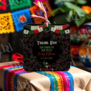 May include: A square black tag with the text "Thank You for coming to our Fiesta" and the names "Emily & James" and the date "15/09/2025". The tag has a Mexican flag design and fireworks. The tag is tied with a red and white string.