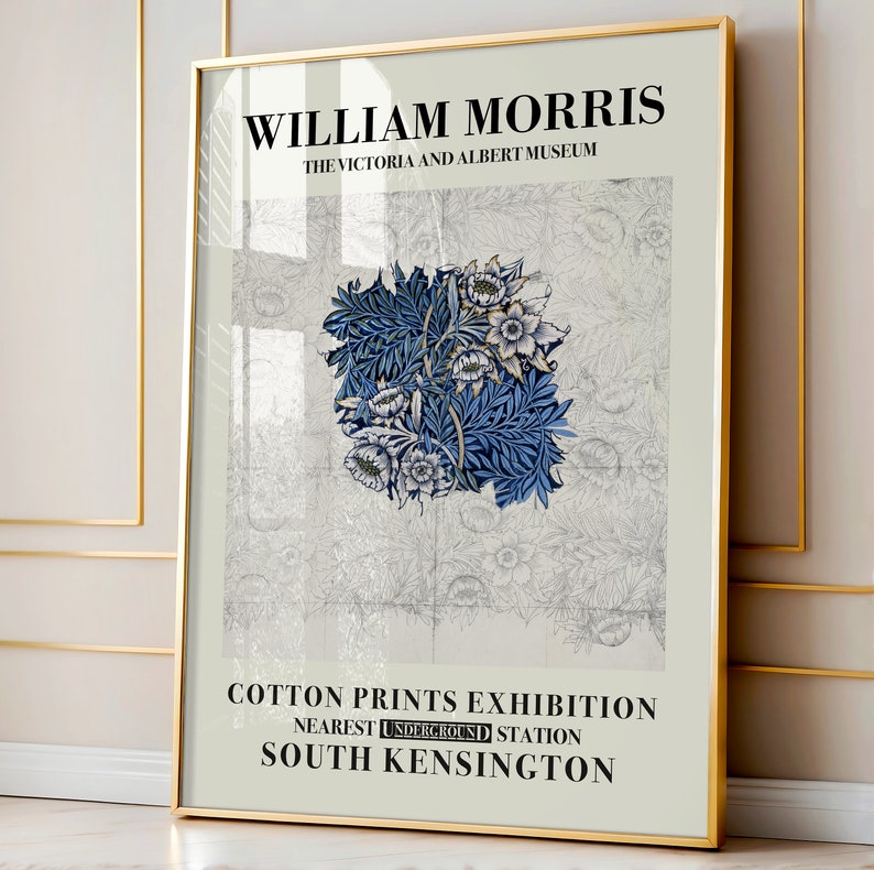 May include: A framed art print featuring a floral design in shades of blue and white, with the text "WILLIAM MORRIS" and "COTTON PRINTS EXHIBITION". The print is displayed in a gold frame.