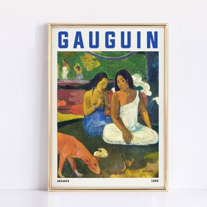 May include: Framed art print of a Gauguin painting featuring two women in white and blue garments, with a red dog in the foreground. The word "GAUGUIN" is in blue block letters at the top.