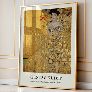 May include: A framed print of Gustav Klimt's "Portrait of Adele Bloch-Bauer I" from 1907. The artwork features a woman in a gold dress with intricate patterns. The frame is gold, and the background is a mix of gold and geometric shapes.