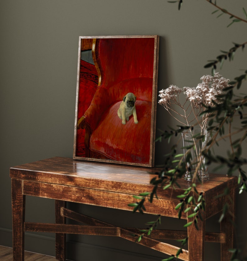 Puede incluir: Una impresi&oacute;n enmarcada con un cachorro de pug sentado en un sill&oacute;n de terciopelo rojo. La impresi&oacute;n tiene un marco de madera y se exhibe sobre una mesa de madera oscura. El cachorro tiene un pelaje marr&oacute;n claro y una cara negra. El fondo es una pared verde oscuro.