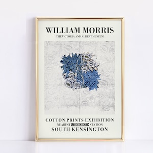 May include: A framed print featuring a William Morris design. The artwork showcases a central blue floral pattern on a light background. Text at the top reads "WILLIAM MORRIS" and "THE VICTORIA AND ALBERT MUSEUM". The bottom text advertises a "COTTON PRINTS EXHIBITION".
