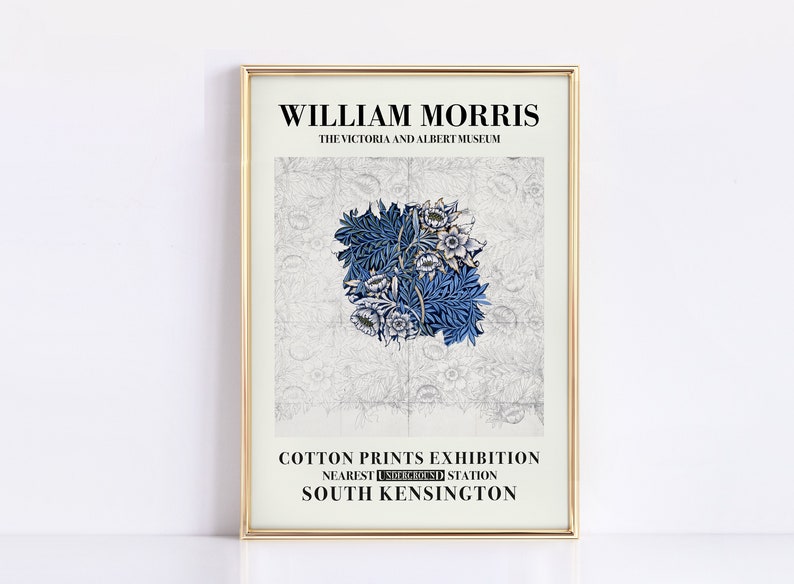 May include: A framed print featuring a William Morris design. The artwork showcases a central blue floral pattern on a light background. Text at the top reads "WILLIAM MORRIS" and "THE VICTORIA AND ALBERT MUSEUM". The bottom text advertises a "COTTON PRINTS EXHIBITION".