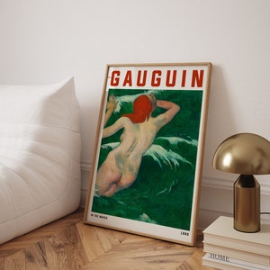 May include: Framed art print of a nude figure in green water, with the text "GAUGUIN" in red. The artwork is titled "IN THE WAVES" and dated 1889. The print is in a wooden frame.