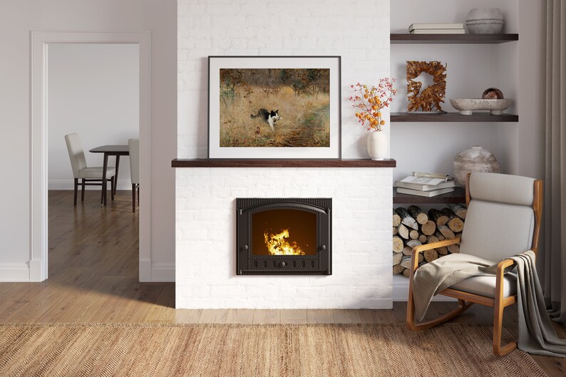 K&ouml;nnte beinhalten: Ein gem&uuml;tliches Wohnzimmer mit einem wei&szlig;en Ziegelkamin und einem gerahmten Bild dar&uuml;ber. Der Kamin hat ein brennendes Feuer. Ein h&ouml;lzerner Schaukelstuhl mit cremefarbenem Kissen steht daneben. Ein Teppich und Regale mit Dekoration vervollst&auml;ndigen das warme Interieur.