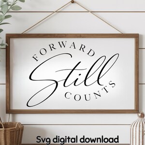 Puede incluir: Un letrero rectangular de madera enmarcado con las palabras "FORWARD Still COUNTS" en escritura negra. El letrero tiene un fondo blanco y un marco de madera marrón. El texto "Svg digital download" está en la parte inferior.