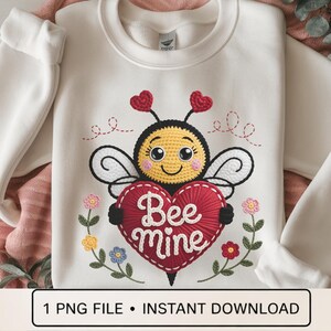 May include: Cream-colored sweatshirt featuring an embroidered bee holding a red heart with "Bee Mine" text. The bee has a yellow body, black and white wings, and red heart antennae. Floral accents surround the heart. The bottom of the image has the text "1 PNG FILE • INSTANT DOWNLOAD".