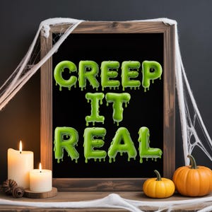 May include: A wooden framed chalkboard with the words "CREEP IT REAL" in green, dripping letters. The Halloween-themed decor includes lit candles, pumpkins, and spiderwebs.
