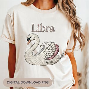 May include: Beige t-shirt featuring a detailed illustration of a swan with pink accents and the word "Libra" above it. The text "DIGITAL DOWNLOAD PNG" is at the bottom. The design is centered on the shirt.