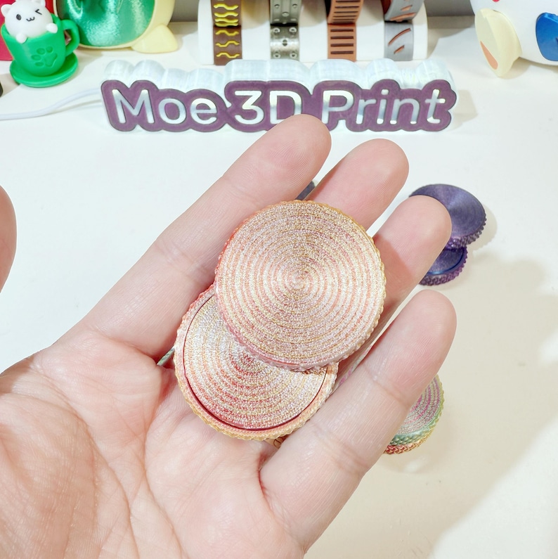 May include: Two round, multi-layered, pink and gold, glitter-covered, decorative coasters.