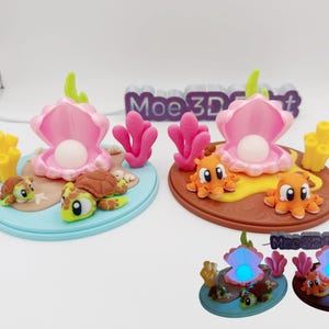 May include: Two decorative ocean-themed night lights. One features a blue base with turtles, the other a brown base with orange octopuses. Both have a pink shell with a pearl and coral accents. The text "Moe 3D Print" is visible.