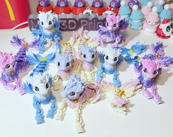May include: A collection of 10 small, colorful, 3D printed figurines of mythical creatures with wings and tails. The figurines are made in shades of pink, blue, purple, and white.