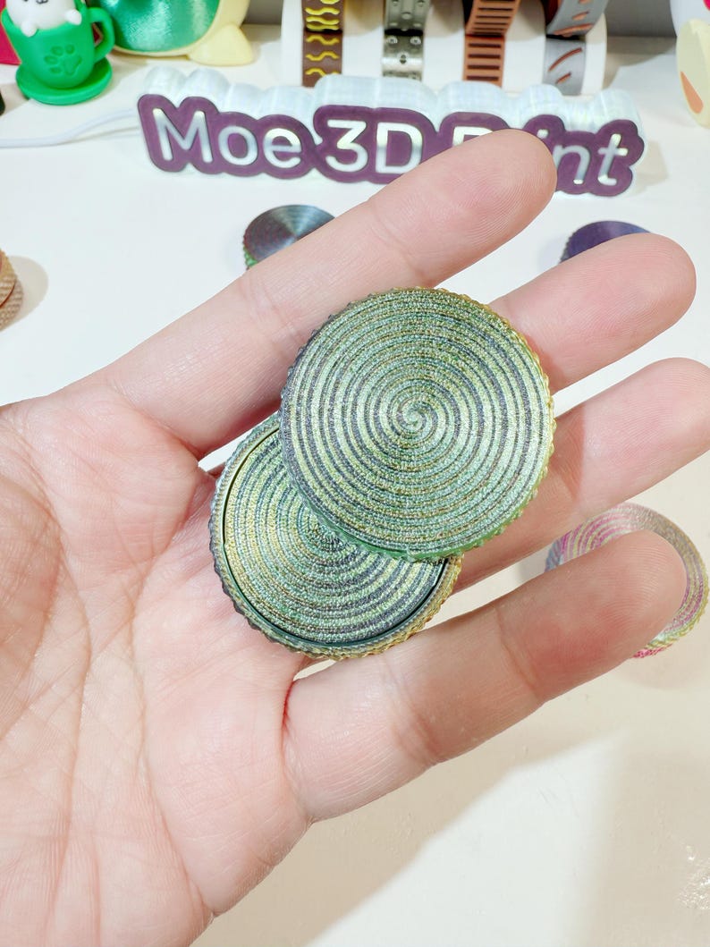 May include: Two round, green and gold, layered, decorative coasters with a spiral pattern.