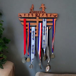 Soccer Medal Hanger Laser Engraved with name and soccer images, also available for all sports.