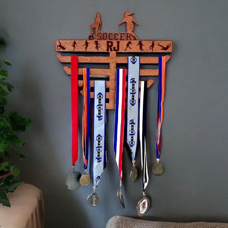 Soccer Medal Hanger Laser Engraved with name and soccer images, also available for all sports.
