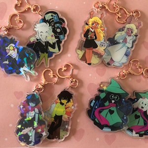 Könnte beinhalten: Satz mit sechs holografischen Charakter-Schlüsselanhängern mit Figuren aus dem Videospiel Deltarune. Die Schlüsselanhänger sind aus klarem Acryl gefertigt und zeigen eine Vielzahl von Charakteren, darunter Kris, Susie, Ralsei, Lancer und der König.