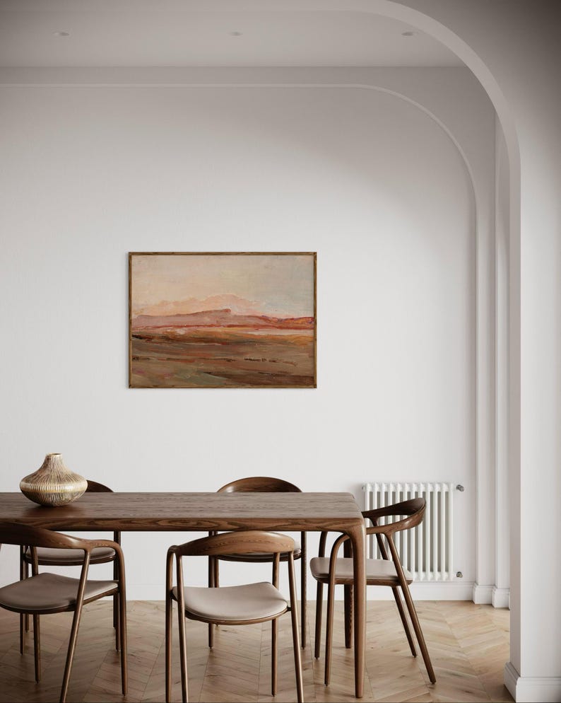 May include: A dining room scene featuring a rectangular wooden table with six matching chairs. A landscape painting hangs on the white wall above the table. A decorative vase sits on the table. The room has a neutral color palette.