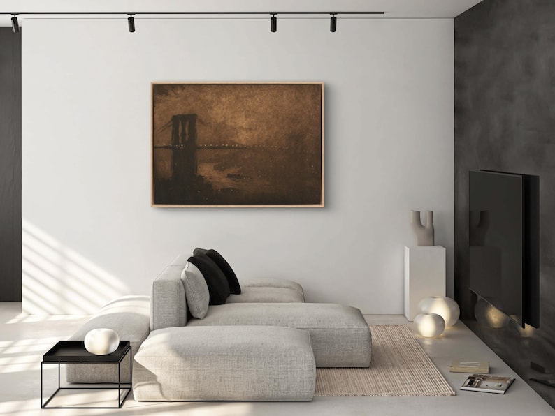 May include: A framed sepia-toned painting of a bridge over water. The bridge is silhouetted against a hazy sky. The painting is hanging on a white wall in a modern living room.