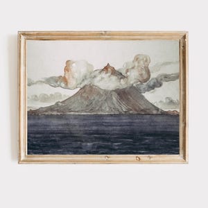 May include: Watercolor painting of a volcano erupting, framed in a light wood frame. The artwork depicts a mountain with a dark gray base and a reddish-brown peak, with white and orange clouds. The sea is a dark blue.
