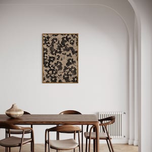 May include: A wooden dining table with six chairs. The table is brown and has a natural wood finish. The chairs are also brown and have a light beige fabric seat. A framed black and white abstract print hangs on the wall behind the table.