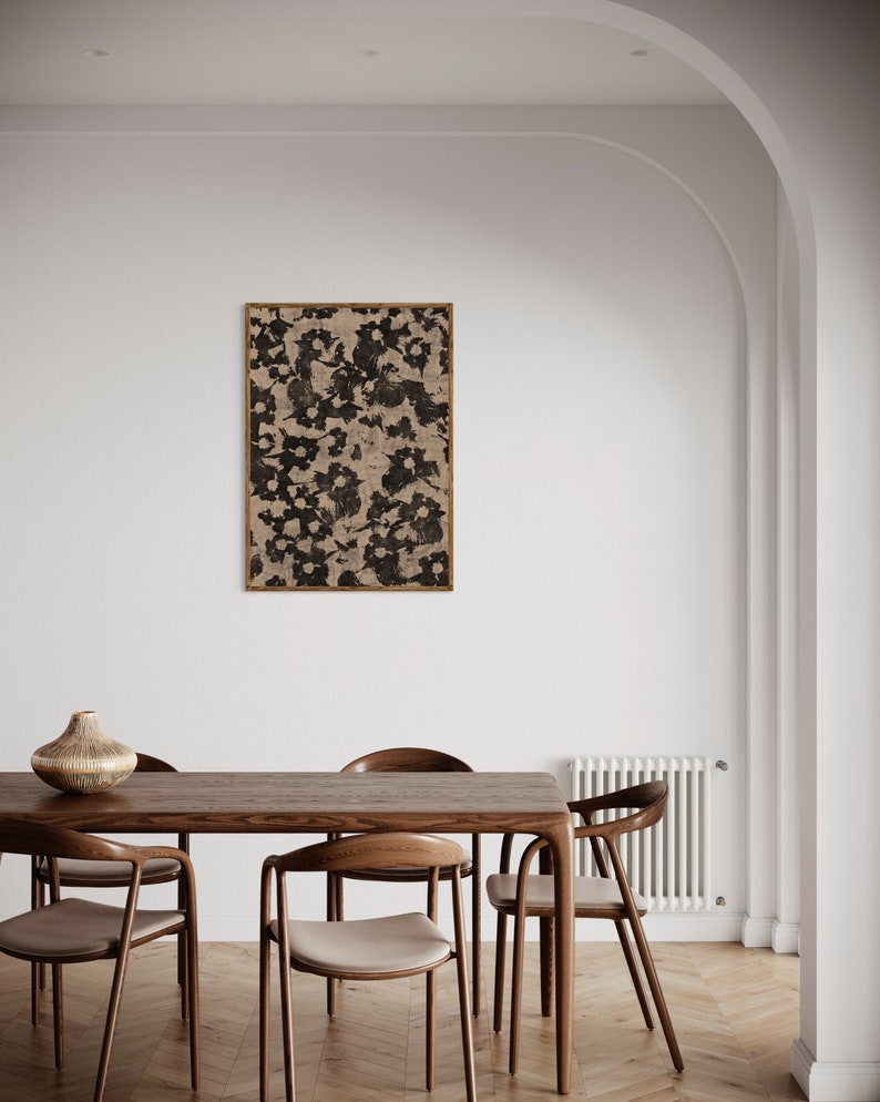 May include: A wooden dining table with six chairs. The table is brown and has a natural wood finish. The chairs are also brown and have a light beige fabric seat. A framed black and white abstract print hangs on the wall behind the table.