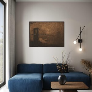 May include: A blue sectional sofa with a wooden coffee table in front of it. A vase with dried flowers sits on the table. A framed print of a bridge over water hangs on the wall behind the sofa.