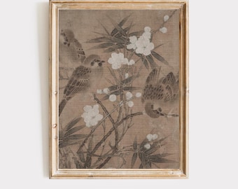 Op de afbeelding: Een ingelijste vintage prent met een sepia-kleurige illustratie van vogels op takken met witte bloesems en bamboebladeren. Het kunstwerk heeft een verouderde uitstraling, met een goudkleurige lijst.