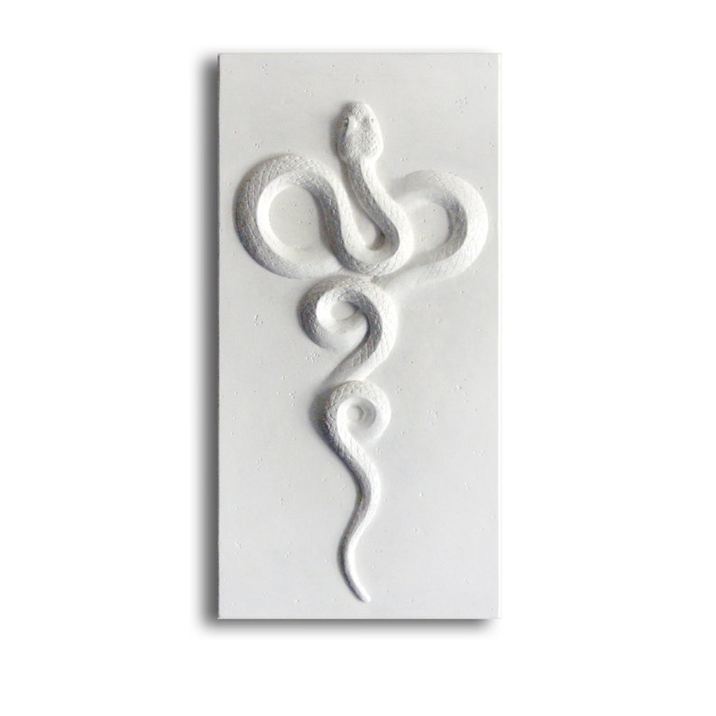 Relief sculpture of a white snake gracefully wriggling on a rectangular base.