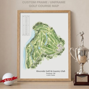 May include: A framed watercolor map of the Riverside Golf & Country Club in Portland, OR, showing 6,684 yards. The print includes a scorecard table, a golf ball with a red ribbon, and a silver trophy featuring a golfer figure on a base.