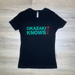 May include: Black t-shirt with the text "OKAZAKI KNOWS" in green and the Japanese characters "横山流" in red.