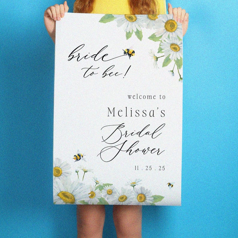 May include: A white bridal shower sign with the text "Bride to bee!" and "Melissa's Bridal Shower" in elegant script. The sign is decorated with watercolor daisies and bees. The date 11.25.25 is also included.