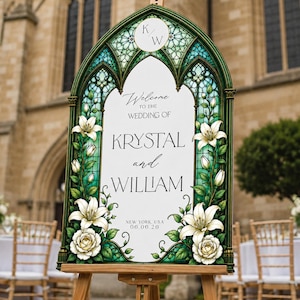 K&ouml;nnte beinhalten: Ein bogenf&ouml;rmiges Hochzeits-Willkommensschild mit einem gr&uuml;nen Buntglasrahmen und Illustrationen von wei&szlig;en Lilien und Rosen. Das wei&szlig;e Mittelfeld zeigt den Text: Welcome to the wedding of Krystal and William, New York, USA, 06.06.26, mit K/W oben.