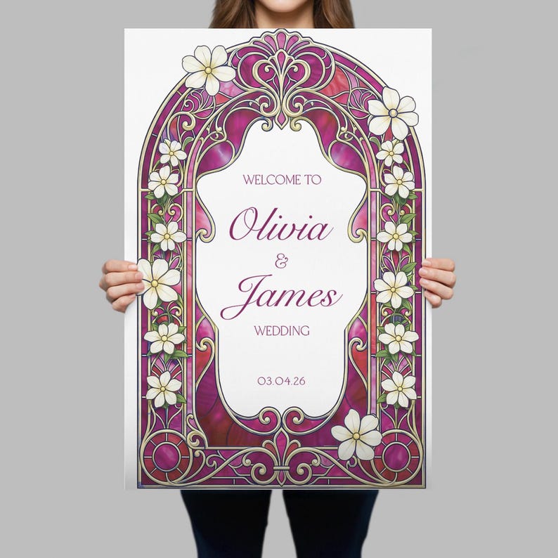 May include: A rectangular wedding welcome sign featuring a magenta and gold stained glass arch frame decorated with white flowers. The centre text reads: WELCOME TO Olivia & James WEDDING 03.04.26 in a mix of serif and script fonts.