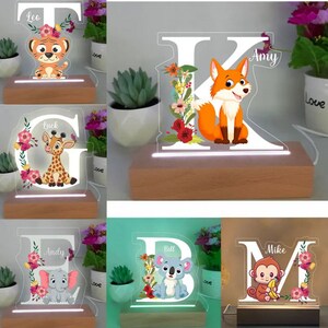 May include: Five personalized wooden night lights with a clear acrylic letter and animal illustration. The letters are T, K, G, B, and M. The animals are a tiger, fox, giraffe, koala, and monkey. Each light has a name on it: Leo, Amy, Luck, Bill, and Mike.