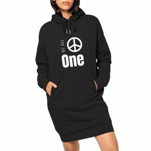 Peut inclure: Robe pull à capuche noire avec un symbole de paix blanc et les mots "We Are One" imprimés sur le devant.