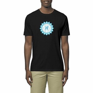Peut inclure: Un t-shirt noir avec un symbole de chakra bleu et blanc sur le devant. Le symbole est un triangle stylisé avec une lettre sanskrite au centre.