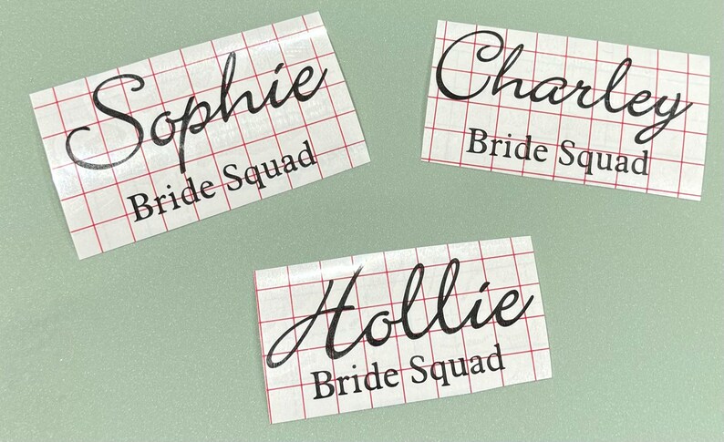 May include: Three white labels with black text on a green background. The labels read "Sophie Bride Squad", "Charley Bride Squad", and "Hollie Bride Squad".