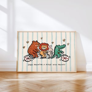 May include: A framed print featuring a bear, lion, rabbit, and alligator riding a tandem bicycle. The illustration is in a cartoon style with a cream background, blue stripes, and stars. The text reads, "EVERY ADVENTURE IS BETTER WITH FRIENDS."