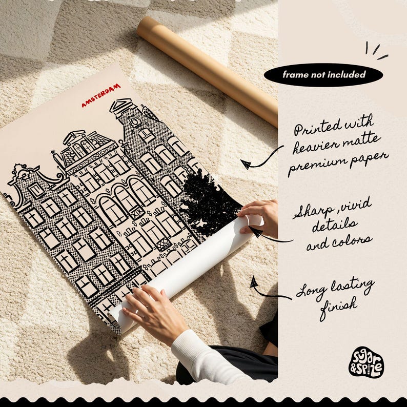 May include: Black and white architectural print of Amsterdam buildings, with the city name in red. The print is on matte paper and rolled up. Text on the image says "frame not included", "Printed with heavier matte premium paper", "Sharp, vivid details and colors", and "Long lasting finish".